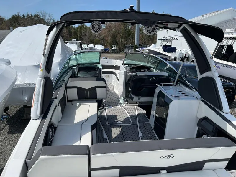 Slide: The Image of 2020 Monterey 275 Super Sport boat interior with seating and helm, docked outdoors. - 9