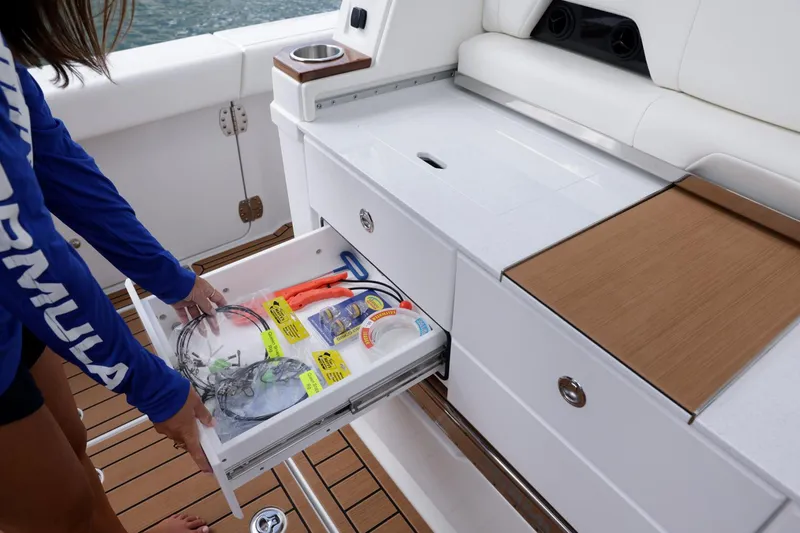 Slide: The Image of 2023 Formula 387 Center Console Fish boat with open storage drawer and fishing gear. - 12