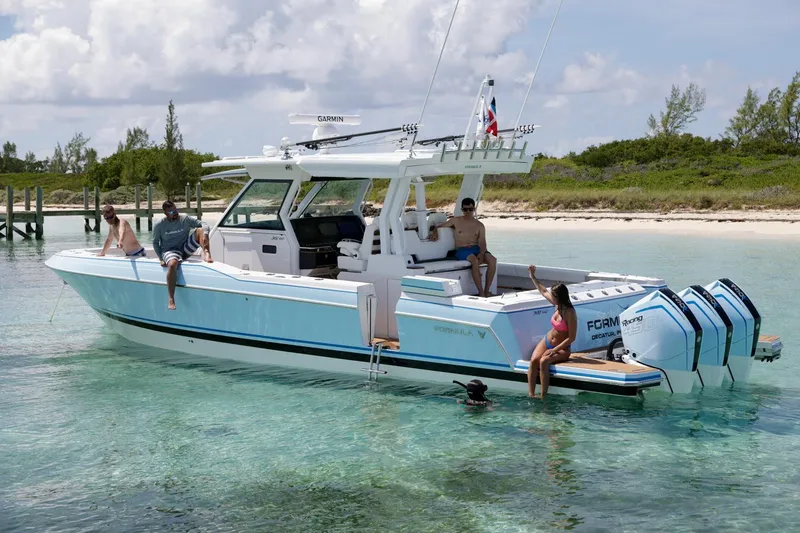 Slide: The Image of 2023 Formula 387 Center Console Fish boat in clear water with people relaxing onboard. - 3