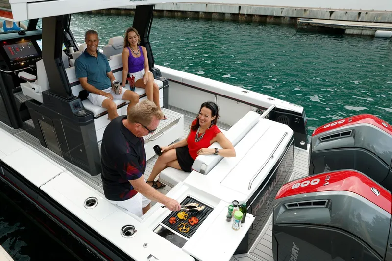 Slide: The Image of 2023 Formula 387 Center Console Sport boat with people enjoying a barbecue on deck. - 10
