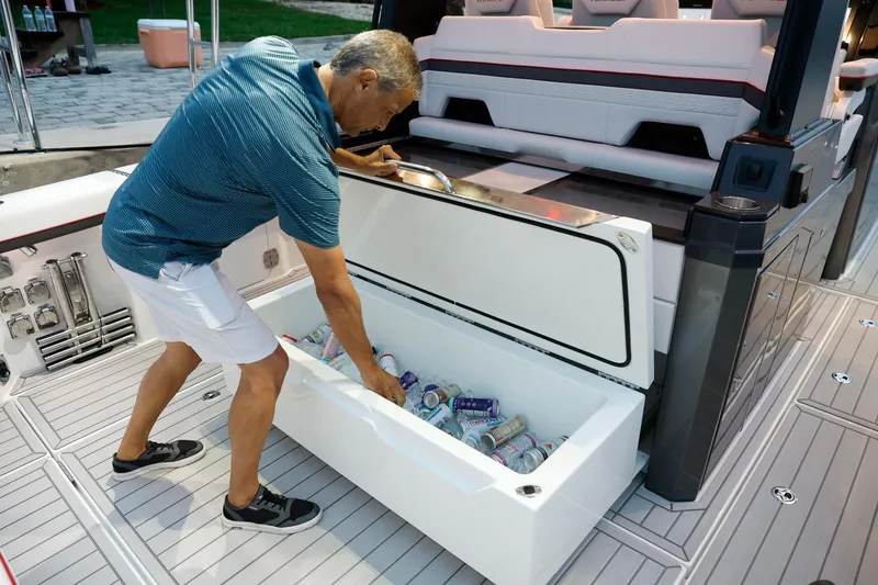 Slide: The Image of Man accessing cooler on 2023 Formula 387 Center Console Sport boat. - 12
