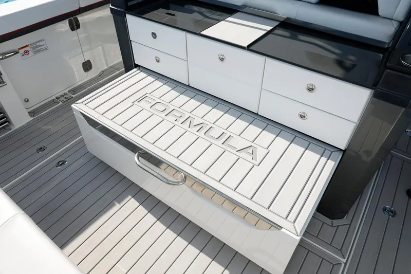 Slide: The Image of 2023 Formula 387 Center Console Sport boat interior with storage compartments and branded deck. - 13