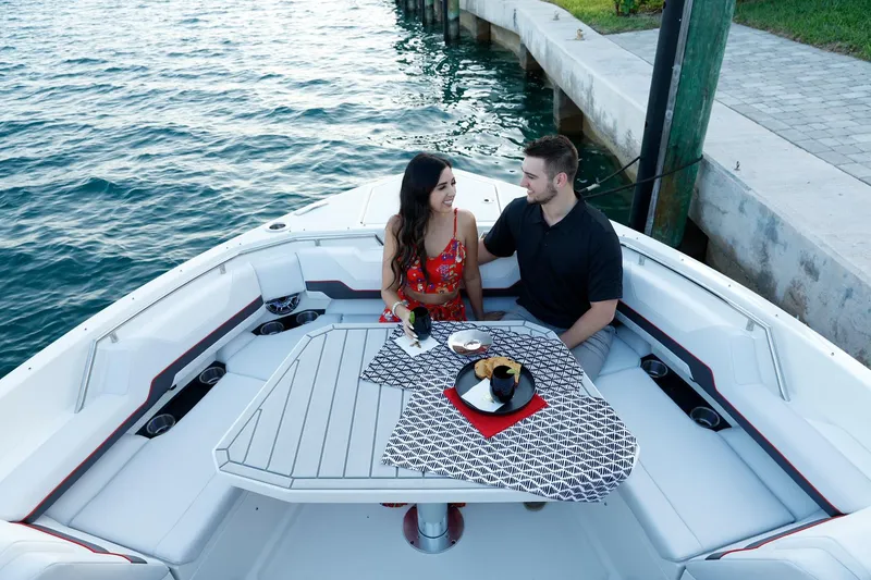 Slide: The Image of Couple dining on a 2023 Formula 387 Center Console Sport boat by the water. - 5