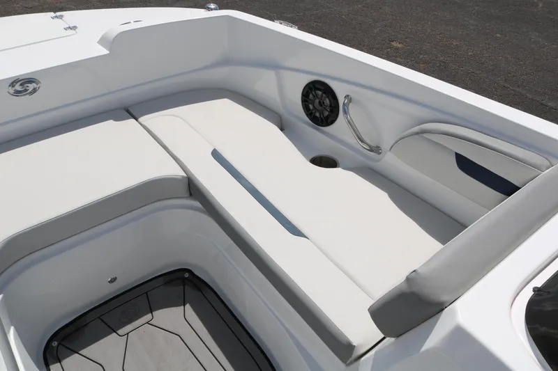 Slide: The Image of 2023 Hurricane SUN DECK 205 OB boat interior with white cushioned seating and speaker. - 14