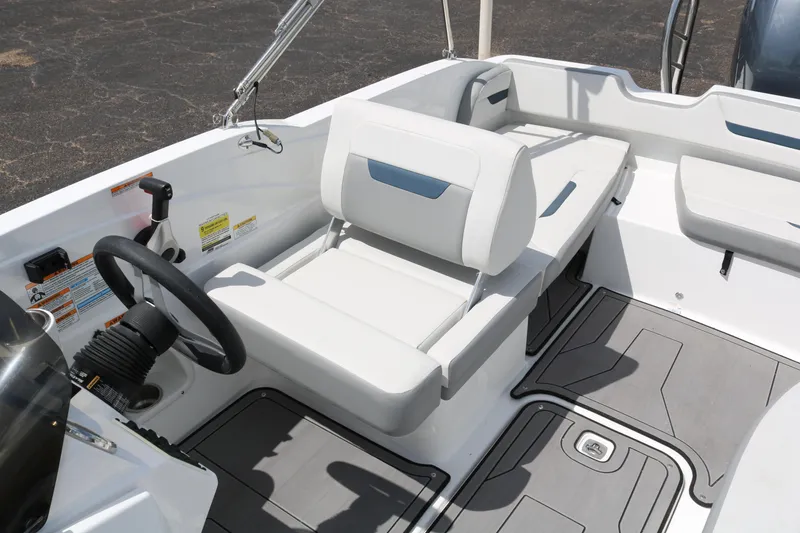 Slide: The Image of 2023 Hurricane SUN DECK 205 OB boat interior with white seating and steering wheel. - 23
