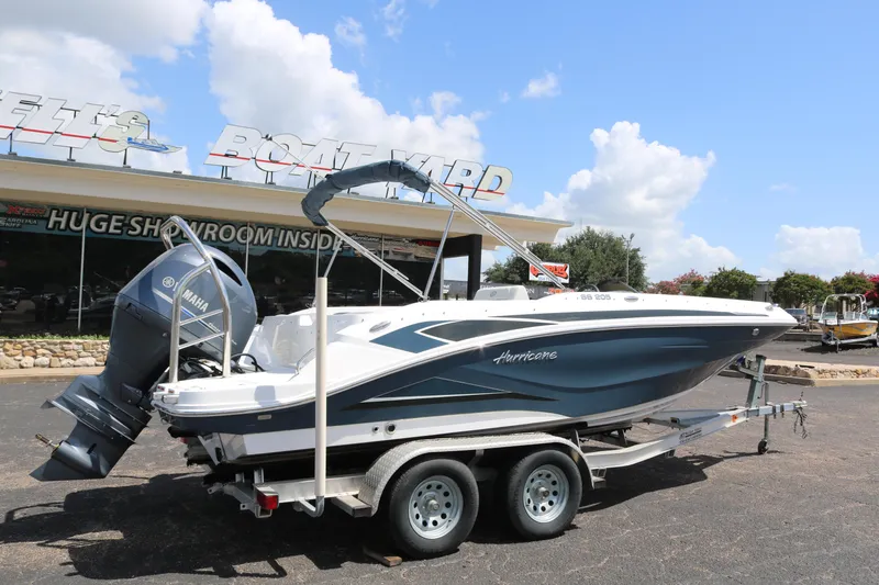 Slide: The Image of 2023 Hurricane SUN DECK 205 OB boat on a trailer outside a showroom. - 6