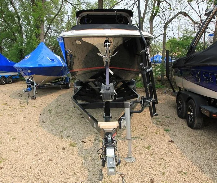 Slide: The Image of A 2016 Regal 2800 Bowrider on a trailer, surrounded by other boats. - 1
