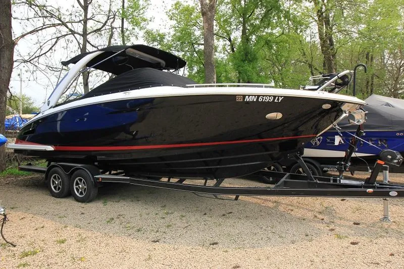 The Image of A 2016 Regal 2800 Bowrider on a trailer, surrounded by trees. - 0