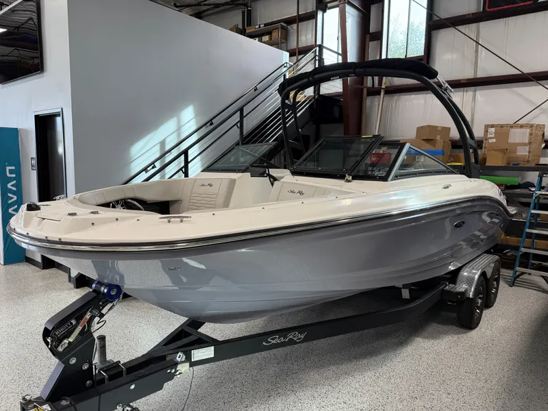 Slide: The Image of 2023 Sea Ray SPX 210 boat on trailer in showroom setting. - 2