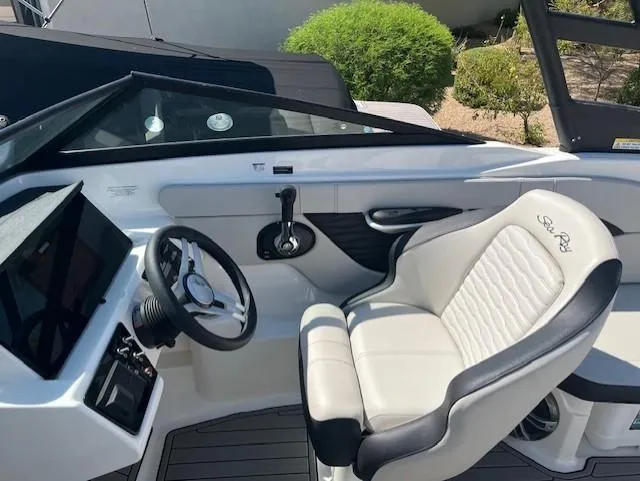 Slide: The Image of 2023 Sea Ray SPX 210 boat interior with steering wheel and captain's seat. - 50