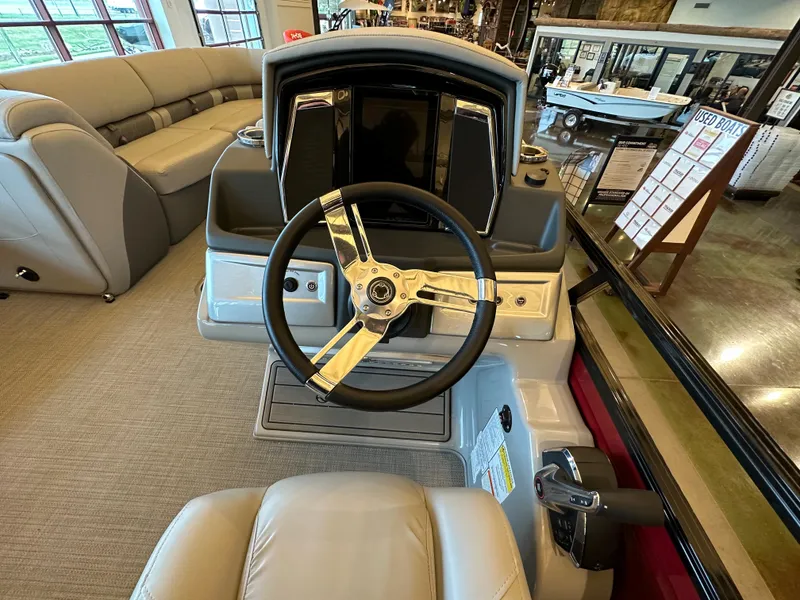 Slide: The Image of 2023 Regency 250 LE3 Sport boat interior, featuring steering wheel and control panel. - 3