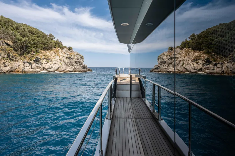 Slide: The Image of Luxury Absolute Navetta 58 yacht cruising between rocky cliffs, 2026 model. - 13