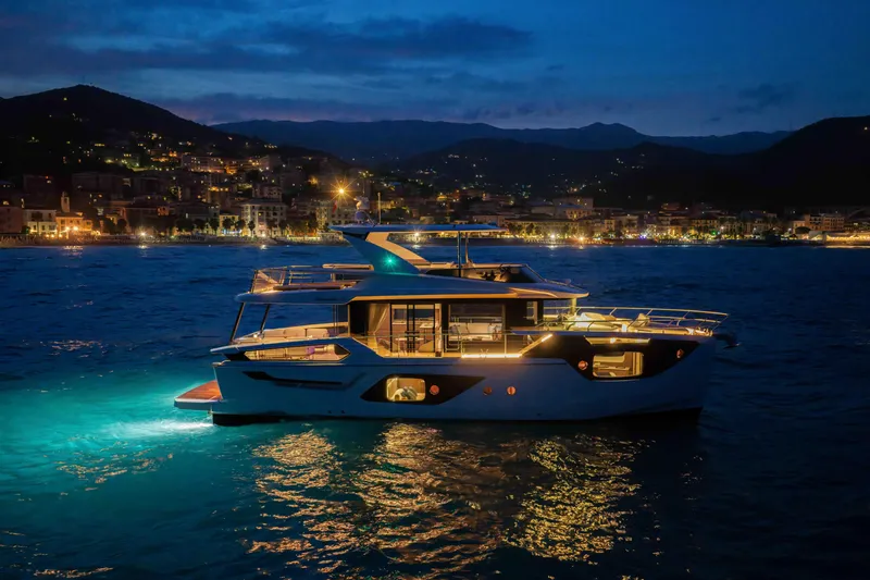 Slide: The Image of Luxurious 2026 Absolute Navetta 58 yacht illuminated at night, cruising near a scenic coastal town. - 56