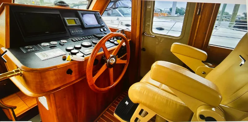 Slide: The Image of 2004 Legacy Downeast boat interior with wooden steering wheel and control panel. - 10