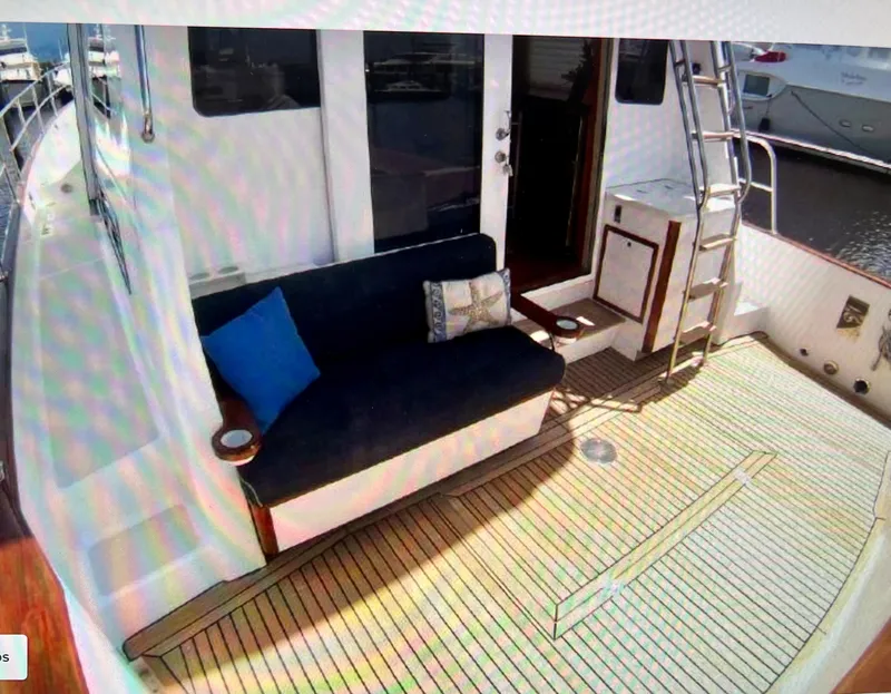 Slide: The Image of 2004 Legacy Downeast boat deck with seating, ladder, and wooden flooring. - 11
