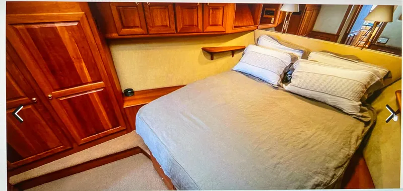 Slide: The Image of Luxurious 2004 Legacy Downeast yacht bedroom with wooden cabinetry and cozy bedding. - 15
