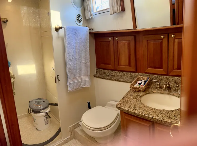 Slide: The Image of Luxurious 2004 Legacy Downeast yacht bathroom with granite countertop and wooden cabinets. - 21
