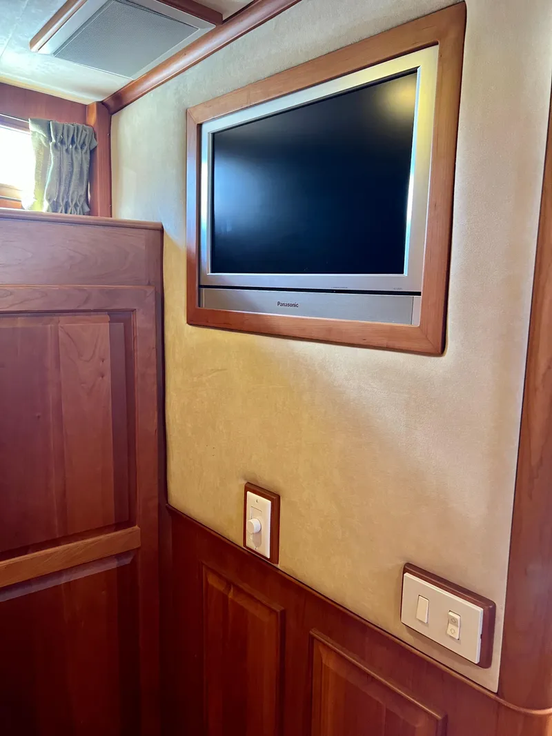 Slide: The Image of 2004 Legacy Downeast interior with wall-mounted TV and wooden paneling. - 23