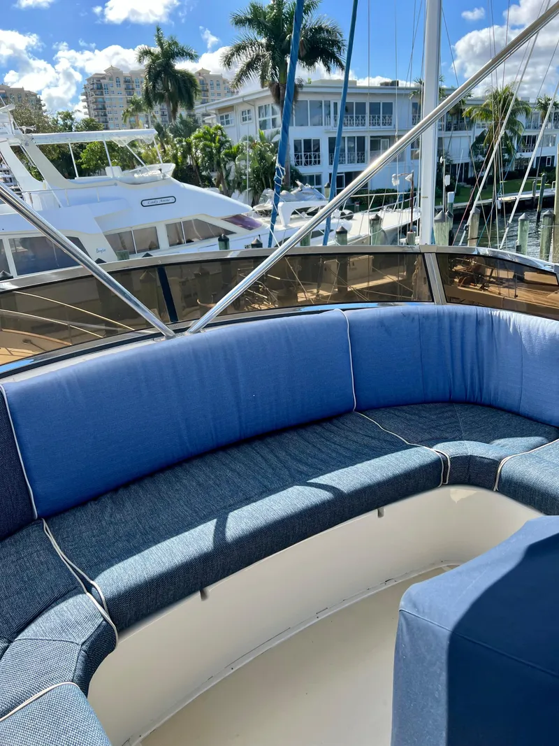 Slide: The Image of 2004 Legacy Downeast boat with blue seating, docked near palm trees and buildings. - 31