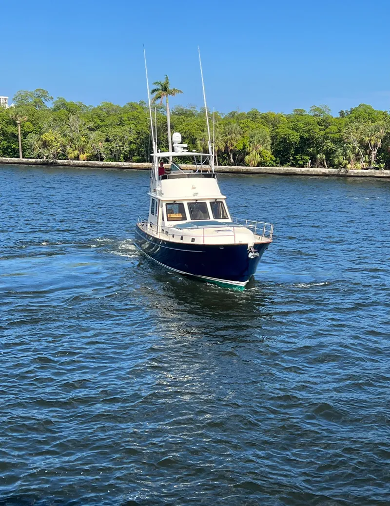 Slide: The Image of 2004 Legacy Downeast boat cruising on a sunny day in a scenic waterway. - 4