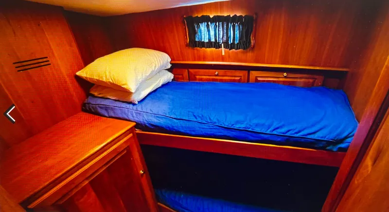 Slide: The Image of Cozy cabin interior of 2004 Legacy Downeast boat with wooden furnishings and blue bedding. - 8