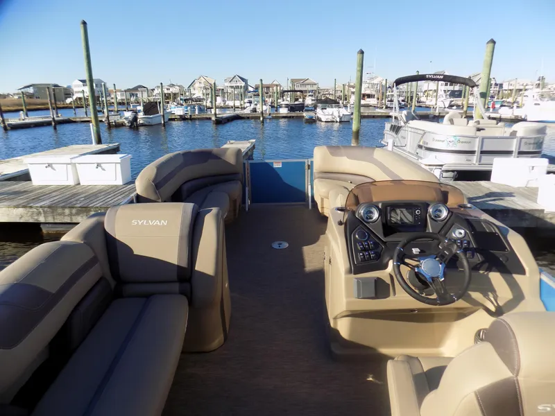 Slide: The Image of 2021 Sylvan L3 Party Fish pontoon boat docked at a marina with plush seating. - 5