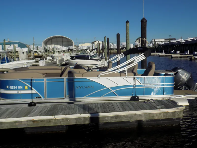 Slide: The Image of 2021 Sylvan L3 Party Fish pontoon boat docked at marina under clear blue sky. - 6