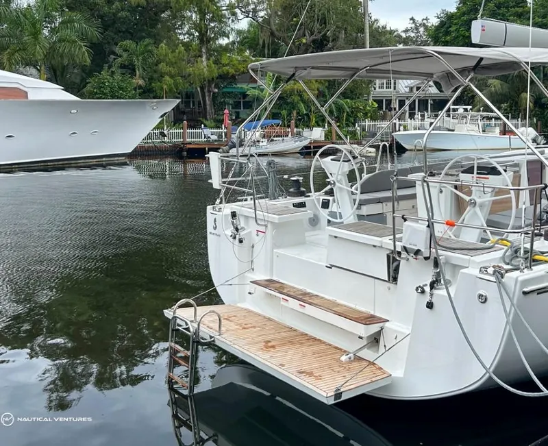 Slide: The Image of 2024 Beneteau Oceanis 51.1 yacht docked in a serene marina setting. - 12