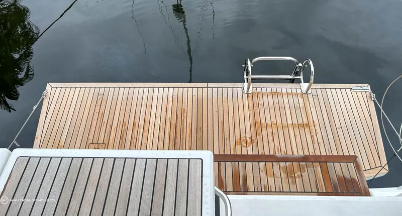 Slide: The Image of Teak swim platform on 2024 Beneteau Oceanis 51.1 yacht, featuring stainless steel ladder. - 13