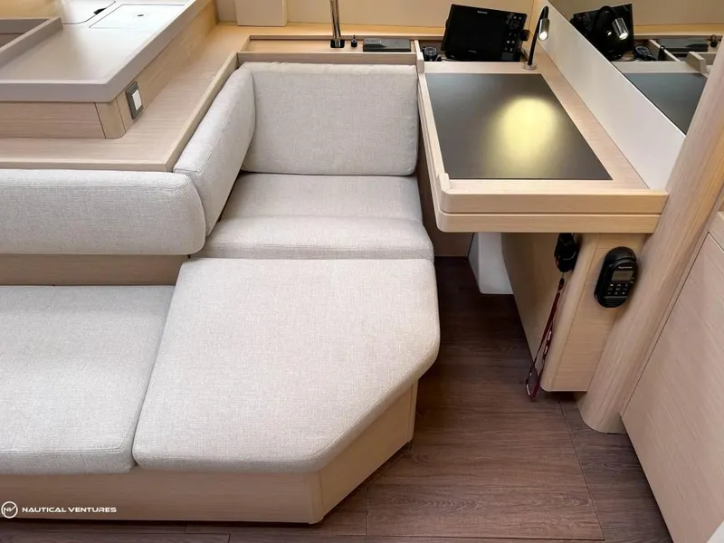 Slide: The Image of Interior of 2024 Beneteau Oceanis 51.1 yacht with beige seating and navigation station. - 23