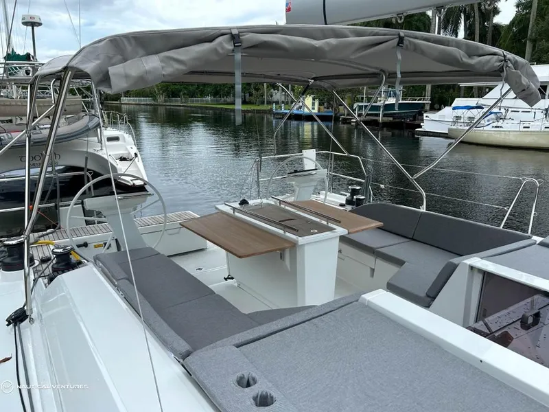 Slide: The Image of 2024 Beneteau Oceanis 51.1 yacht with spacious deck and seating area, docked by a serene waterfront. - 3