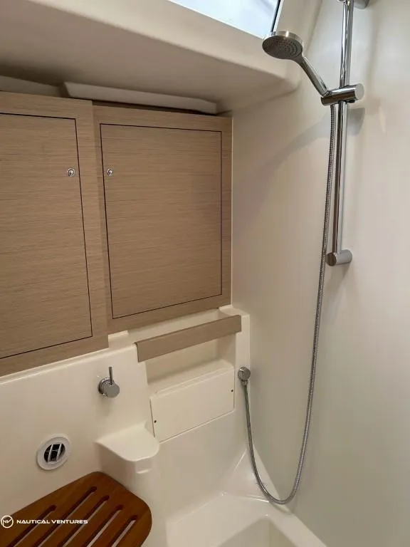 Slide: The Image of 2024 Beneteau Oceanis 51.1 yacht bathroom with shower and wooden seat. - 32