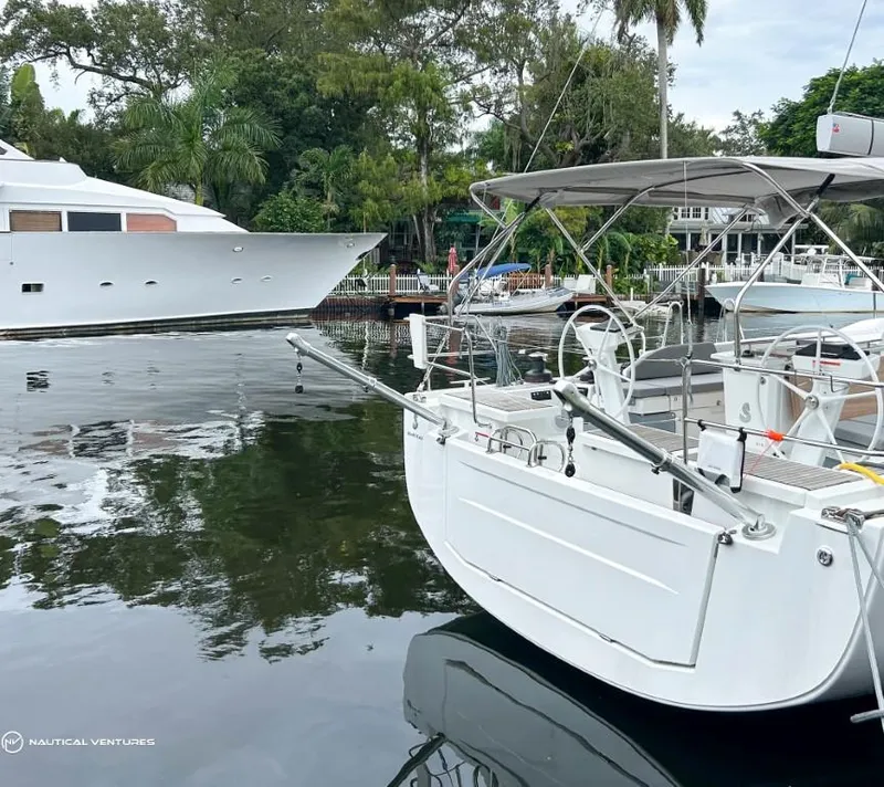 Slide: The Image of 2024 Beneteau Oceanis 51.1 yacht docked in a serene marina setting. - 11