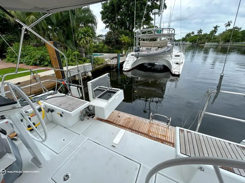 Slide: The Image of Beneteau Oceanis 51.1 yacht deck, 2024 model, docked by a lush, tropical canal. - 7