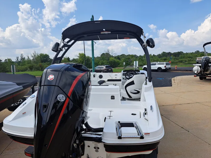 Slide: The Image of 2023 Tahoe 1950 boat with black and white design, rear view, parked on a sunny day. - 1