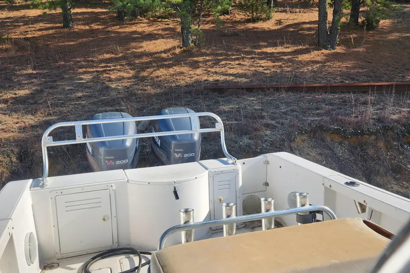 Slide: The Image of 2001 Cobia 274 Center Console boat with dual Yamaha engines in wooded area. - 14