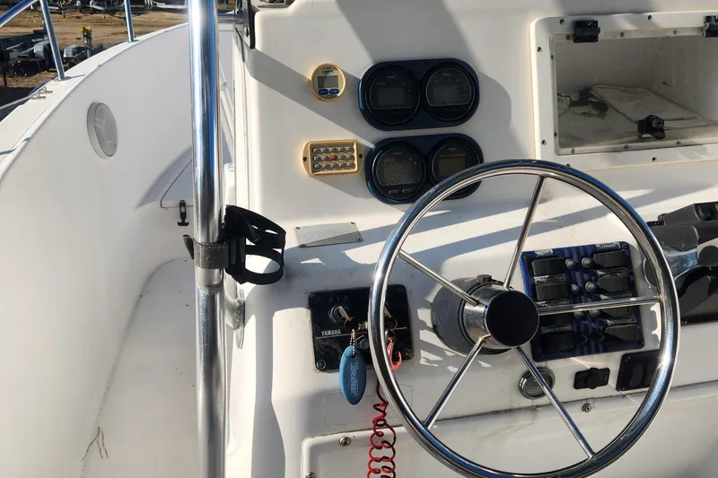 Slide: The Image of 2001 Cobia 274 Center Console boat helm with steering wheel and control panel. - 18