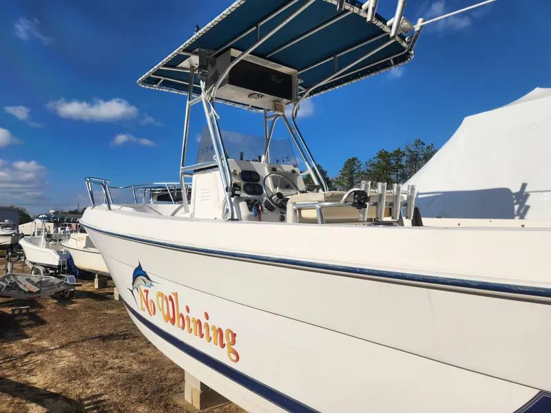Slide: The Image of 2001 Cobia 274 Center Console boat with "No Whining" text, parked outdoors. - 6