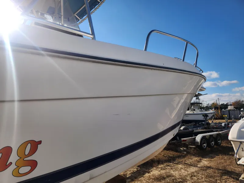 Slide: The Image of 2001 Cobia 274 Center Console boat on trailer under sunny sky. - 9