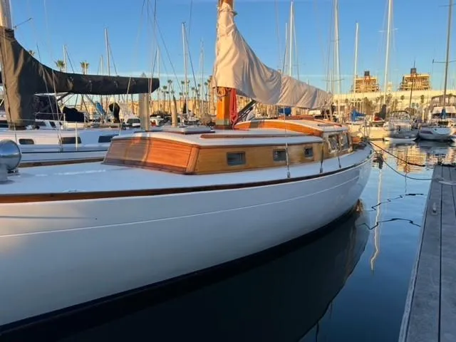 Slide: The Image of Classic 1961 Lapworth 40 sailboat docked in a marina, showcasing elegant wooden cabin design. - 14