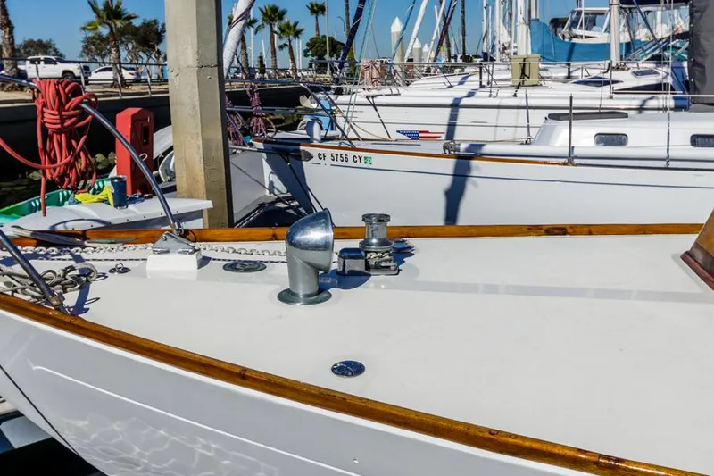 Slide: The Image of 1961 Lapworth 40 sailboat docked, featuring a clean deck and wooden trim. - 16