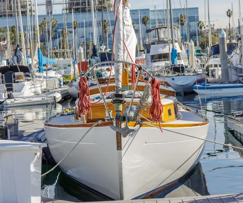 Slide: The Image of Classic 1961 Lapworth 40 sailboat docked in a marina, surrounded by other boats. - 2
