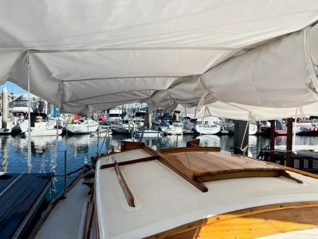 Slide: The Image of 1961 Lapworth 40 sailboat docked in a marina, covered with a white canopy. - 20