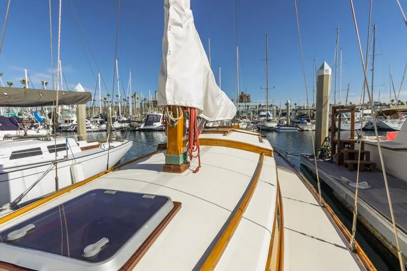 Slide: The Image of 1961 Lapworth 40 sailboat docked in a marina under clear blue skies. - 23