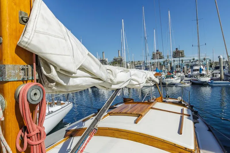 Slide: The Image of Sailboat Lapworth 40, 1961 model, docked in a marina with clear blue skies. - 27