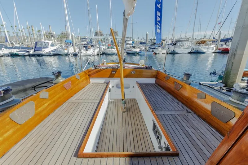 Slide: The Image of 1961 Lapworth 40 sailboat deck with wooden finish, docked at a marina. - 29