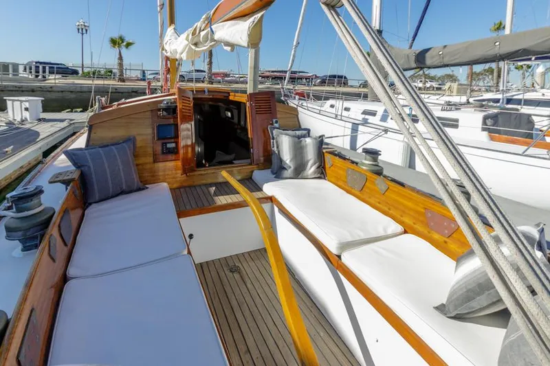 Slide: The Image of 1961 Lapworth 40 sailboat with wooden deck and cushioned seating in a marina. - 3