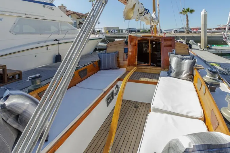 Slide: The Image of Classic 1961 Lapworth 40 sailboat with wooden deck and cushioned seating in a marina. - 31