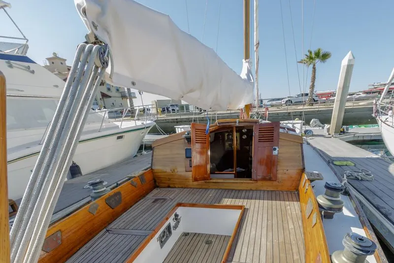 Slide: The Image of Sailboat docked at marina, Lapworth 40 model, 1961, with wooden deck and white sails. - 34