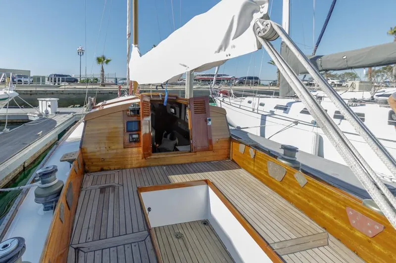 Slide: The Image of 1961 Lapworth 40 sailboat with wooden deck and open cockpit in marina. - 35